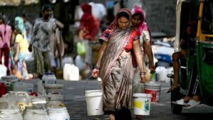 Residents-carry-water-containers-after-filling-them-from-a-municipal-tanker-in-a-low-income-neighbourhood-in-New-Delhi